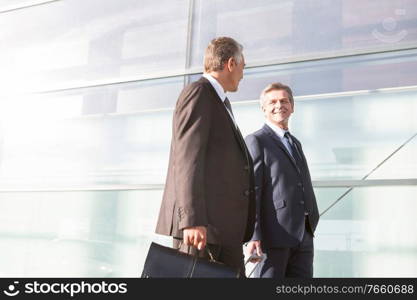 Mature businessmen walking while talking in the airport