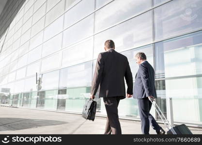 Mature businessmen walking while talking in the airport