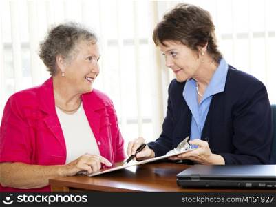 Mature businesswoman discusses a contract with her senior client. Could also be sales related.