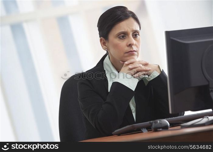 Mature businesswoman looking at computer with concentration