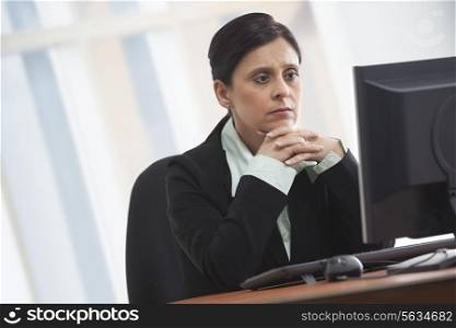 Mature businesswoman looking at computer with concentration