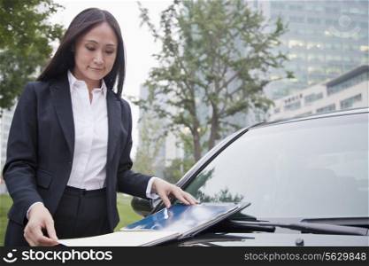 Mature Businesswoman Looking Down Notebook