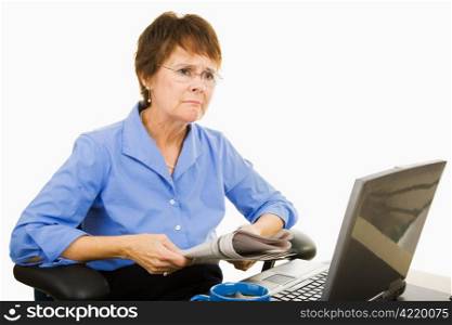 Mature businesswoman upset by the bad news she&rsquo;s reading in the newspaper. Isolated on white.