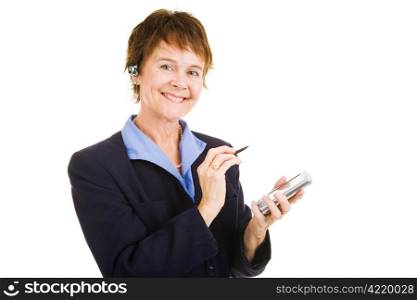 Mature businesswoman with her personal organizer and her hands free telephone earpiece. Isolated