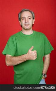 mature casual man going thumb up, on a red background