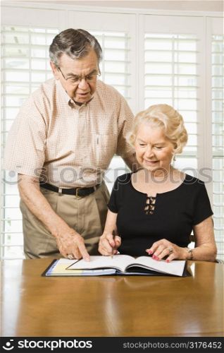 Mature Caucasian couple looking at their calendar.