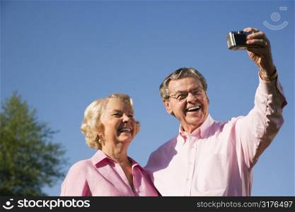 Mature Caucasian couple taking picture of themselves.