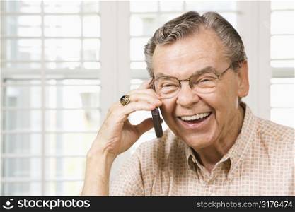 Mature Caucasian man talking on cellphone.