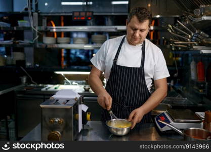 Mature chef wearing apron whisking egg in bowl while cooking pasta food on restaurant kitchen. Culinary recipe for breakfast. Mature chef wearing apron whisking egg in bowl while cooking pasta on kitchen