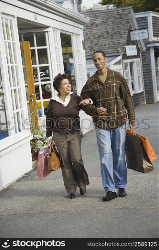 Mature couple carrying shopping bags and smiling
