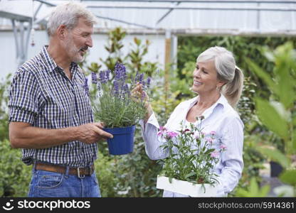 Mature Couple Choosing Plants At Garden Center