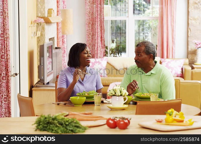 Mature couple eating salad and talking