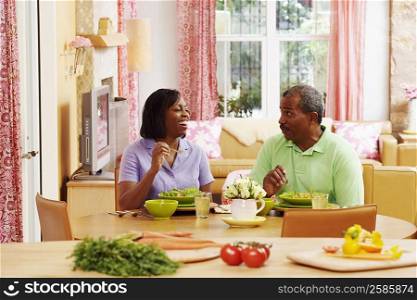Mature couple eating salad and talking