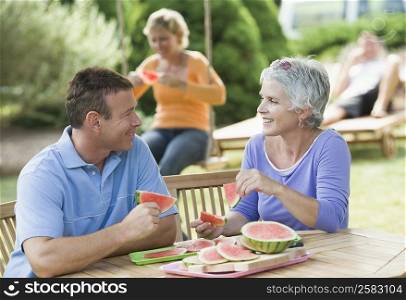 Mature couple eating watermelon slice