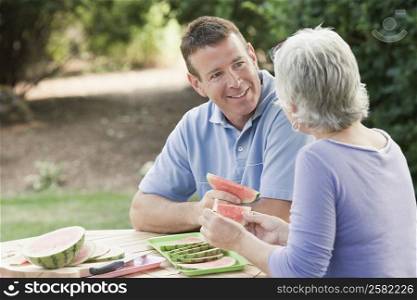Mature couple eating watermelon slices