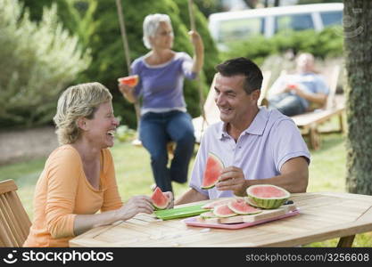 Mature couple eating watermelon slices