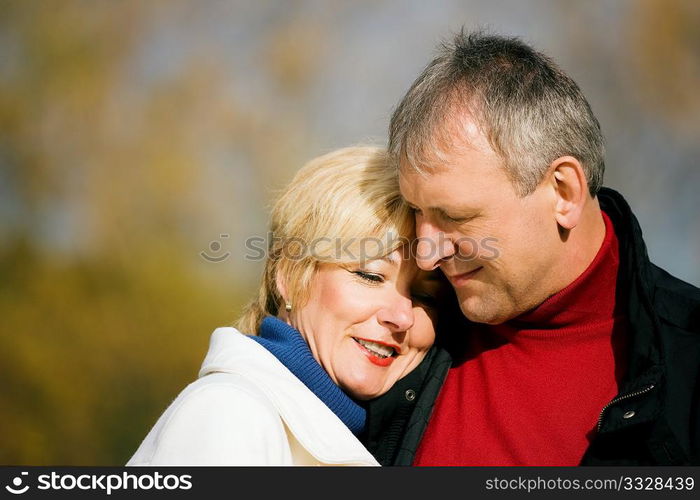 Mature couple having a walk holding each other tight still in love with each other