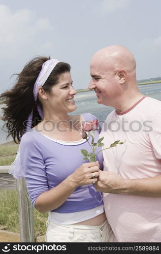 Mature couple holding a rose and smiling