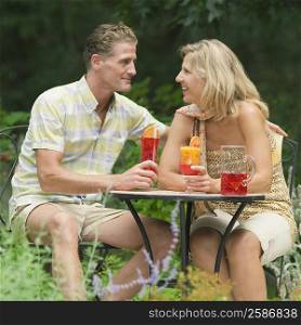 Mature couple holding glasses of juice and smiling
