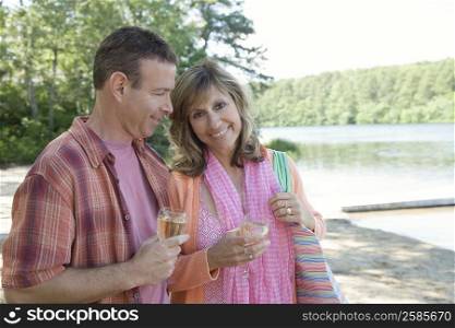 Mature couple holding glasses of wine and smiling