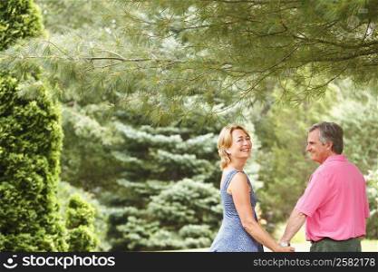 Mature couple holding hands and smiling in a park