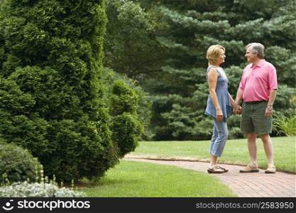 Mature couple holding hands and smiling in a park