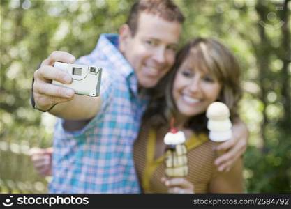 Mature couple holding ice cream cones and taking a picture of themselves