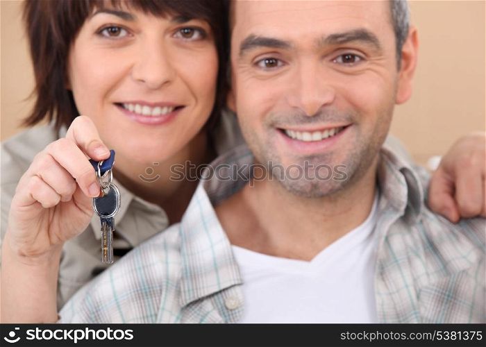 Mature couple holding up a set of keys