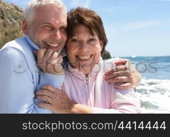 Mature couple hugging by the oceanside
