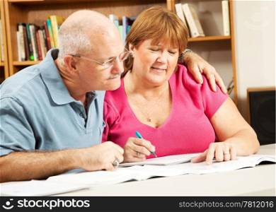 Mature couple in adult education, studying at the library.