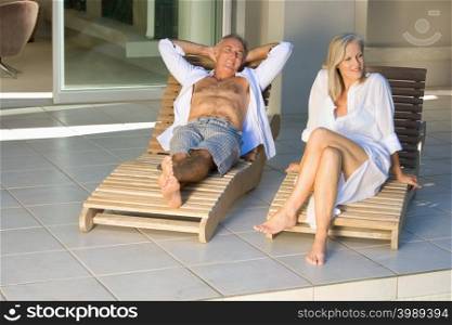 Mature couple in lounge chairs