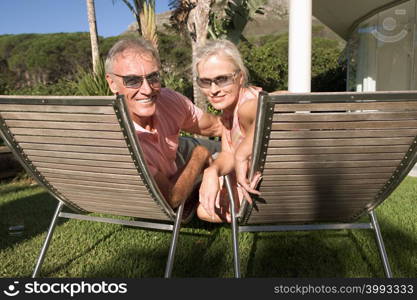 Mature couple in lounge chairs