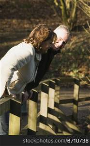 Mature couple leaning on a fence