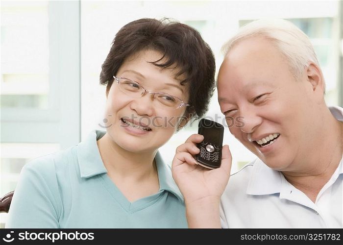 Mature couple listening to a mobile phone