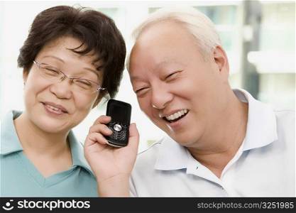 Mature couple listening to a mobile phone