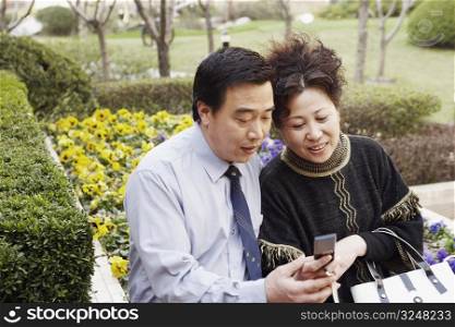 Mature couple looking at a mobile phone smiling