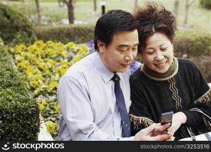 Mature couple looking at a mobile phone smiling