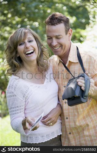 Mature couple looking at a photograph and smiling
