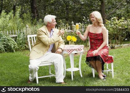 Mature couple looking at each other holding a glass of juice