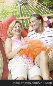 Mature couple lying in a hammock and smiling