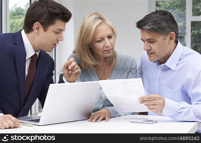 Mature Couple Meeting With Financial Advisor At Home