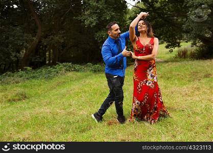 Mature couple outdoors, in field, dancing