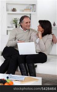 Mature couple relaxing in front of laptop
