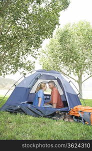 Mature couple sit face to face in tent