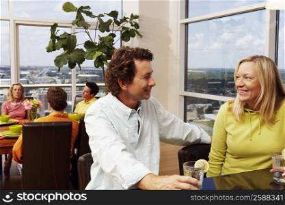 Mature couple sitting at a counter and holding glasses of lemonade