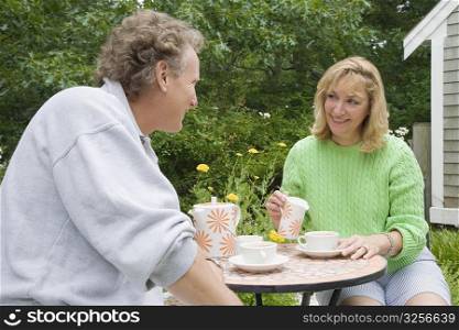 Mature couple sitting at a table and drinking tea