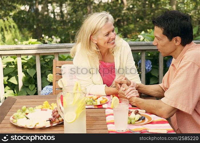 Mature couple sitting at the table and looking at each other