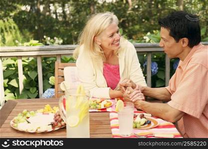 Mature couple sitting at the table and looking at each other