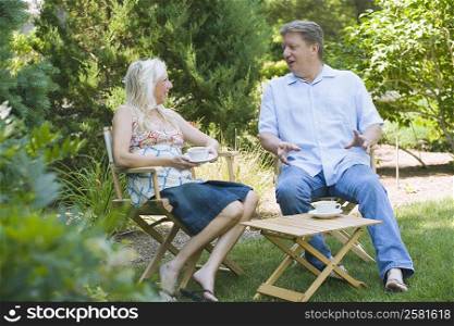 Mature couple sitting in a garden and talking to each other