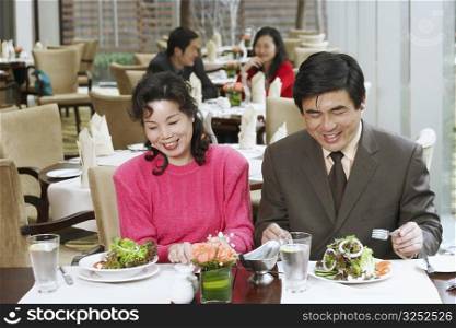 Mature couple sitting in a restaurant smiling